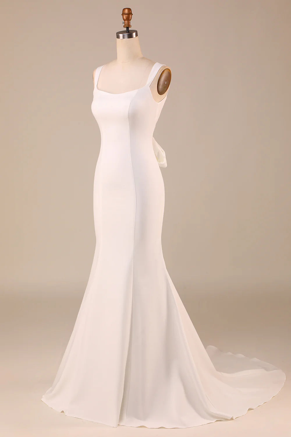 Side profile of the ivory mermaid wedding gown, showcasing its fitted silhouette and flowing train.
