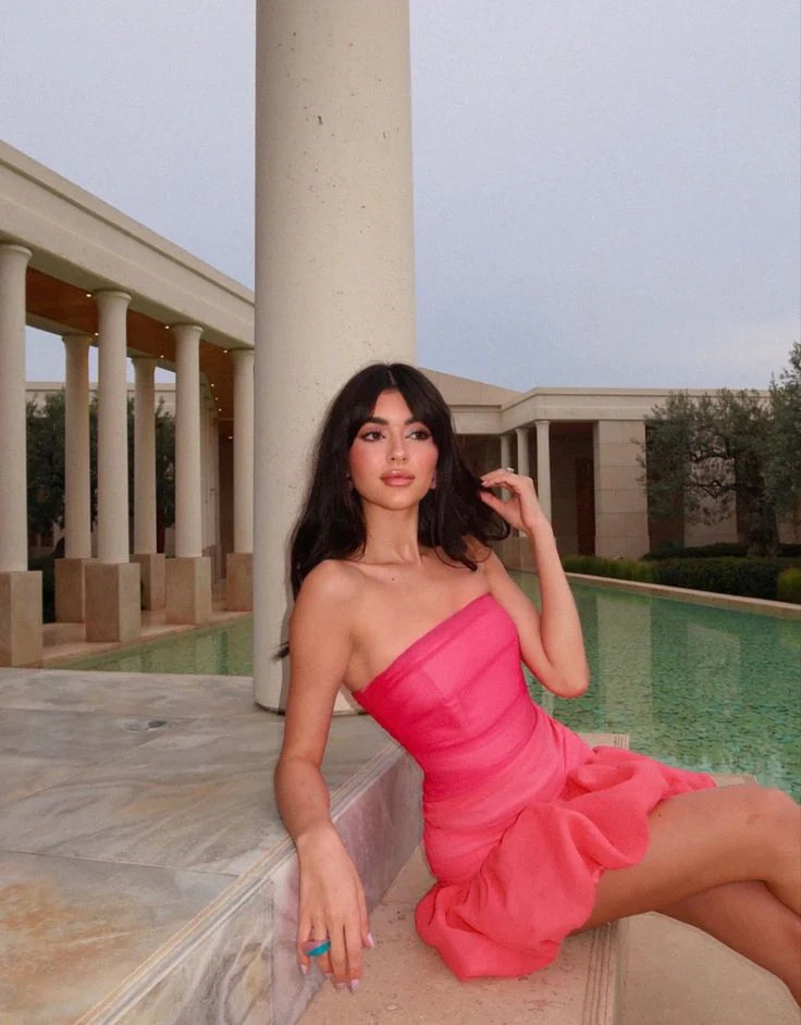 Back view of a pink strapless ruched dress, highlighting the bubble hem.