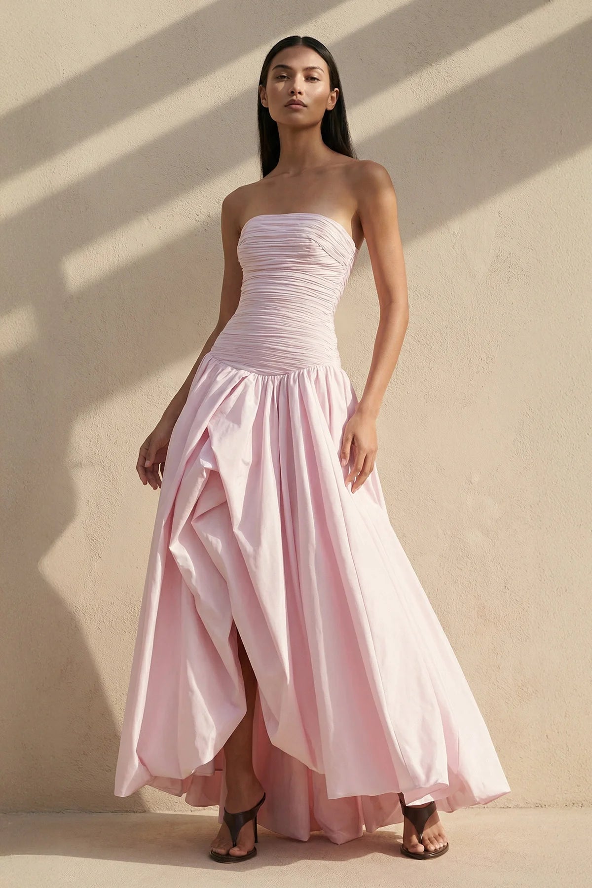 Elegant strapless prom dress with ruched bodice and voluminous drop-waist balloon skirt.