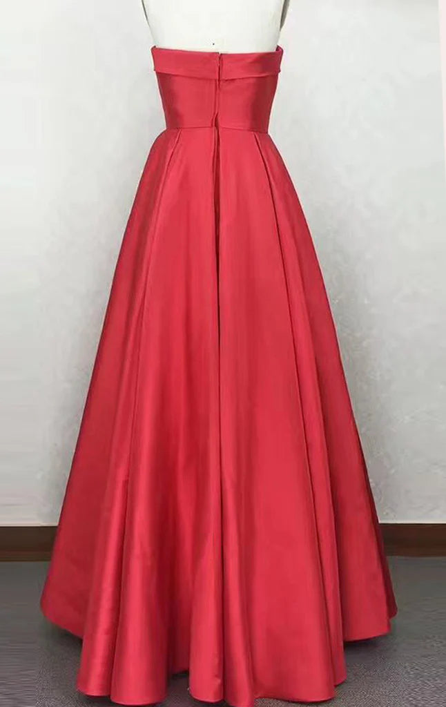 Woman posing in a flowing strapless satin prom dress.