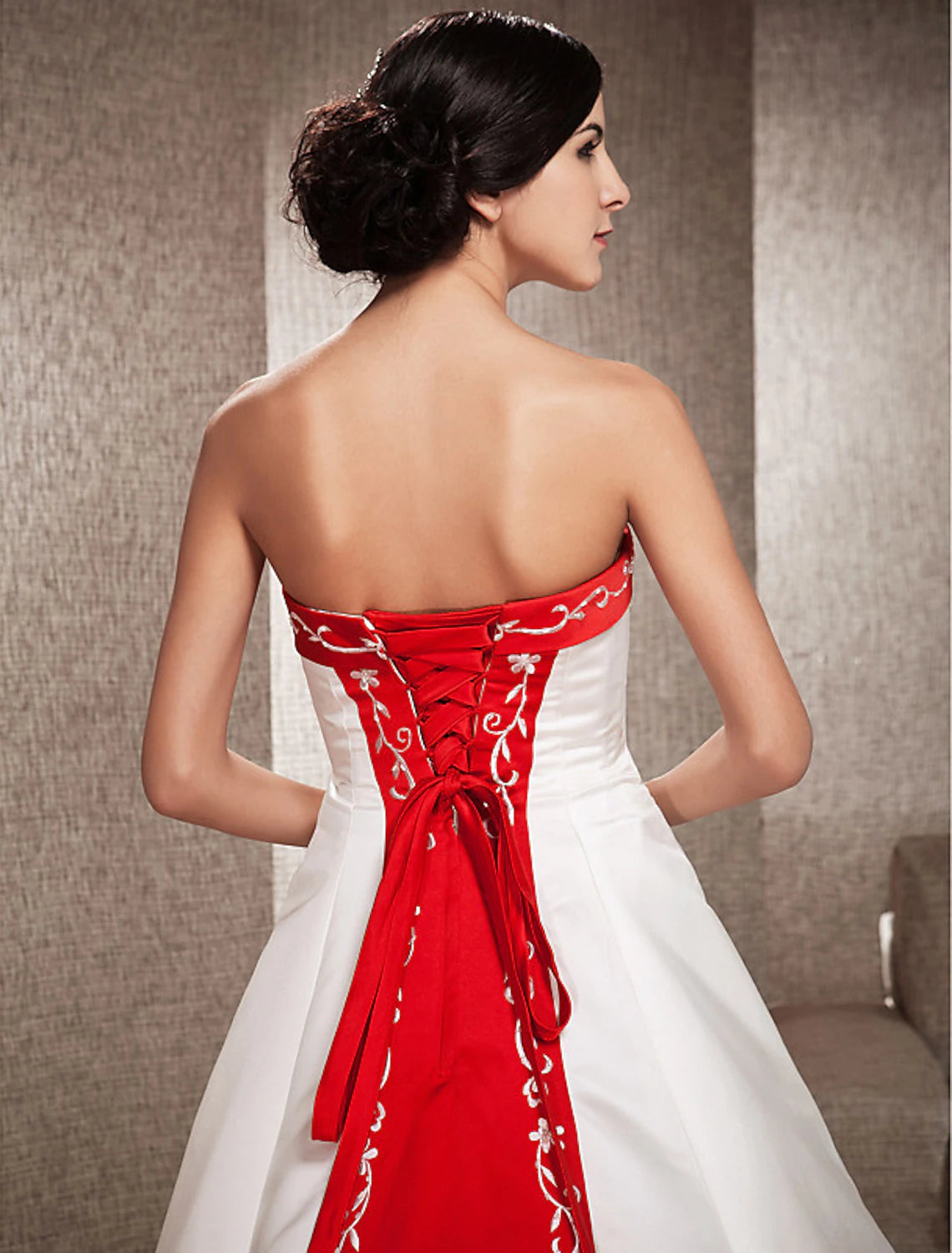 Close-up detail of the delicate embroidery appliques on the satin wedding dress.
