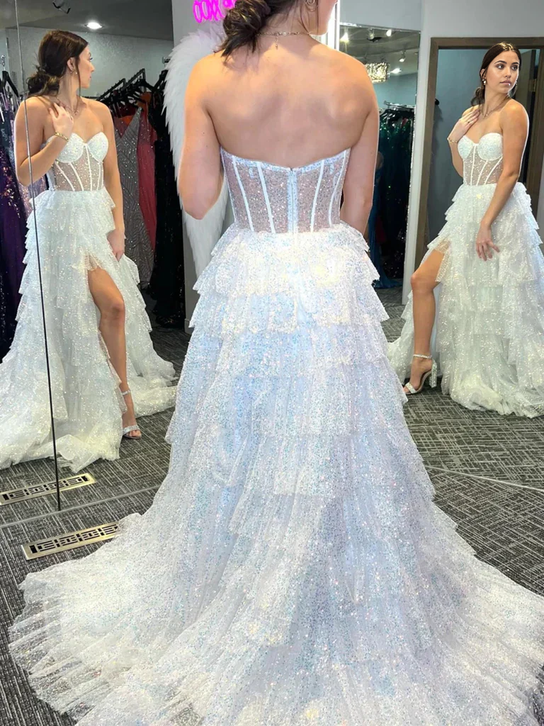Back view of white strapless sequined tulle ruffle formal evening dress.