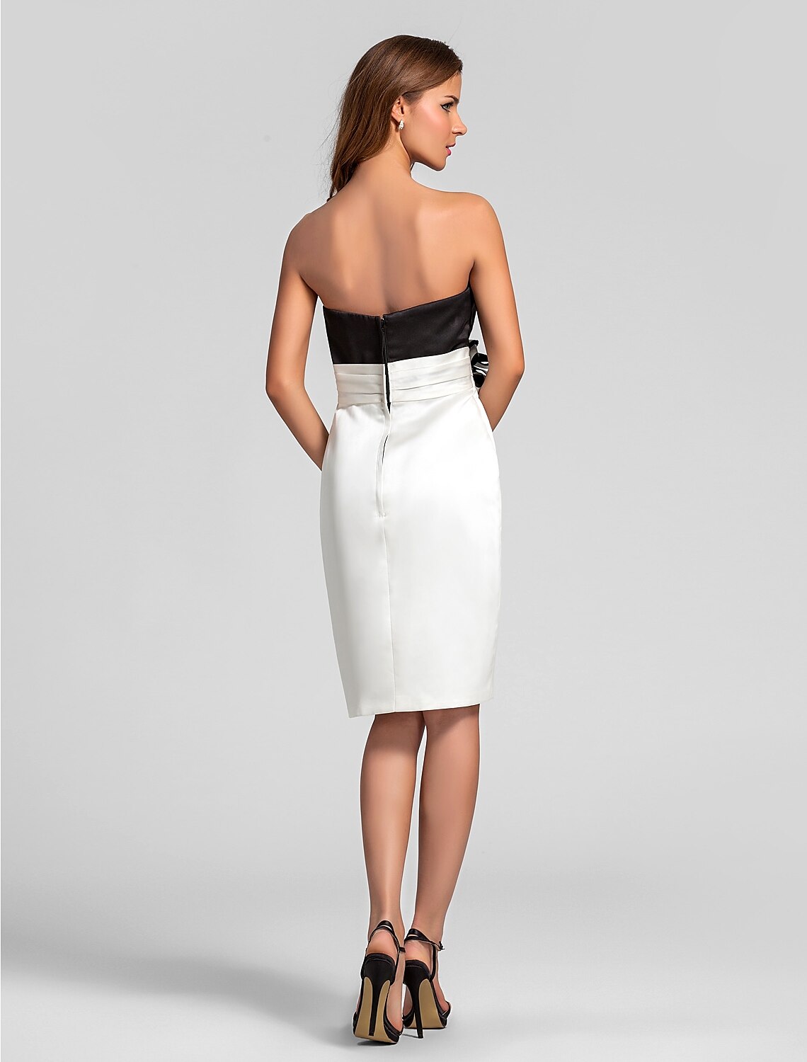 Back view of a model in a strapless satin ruched bridesmaid dress.
