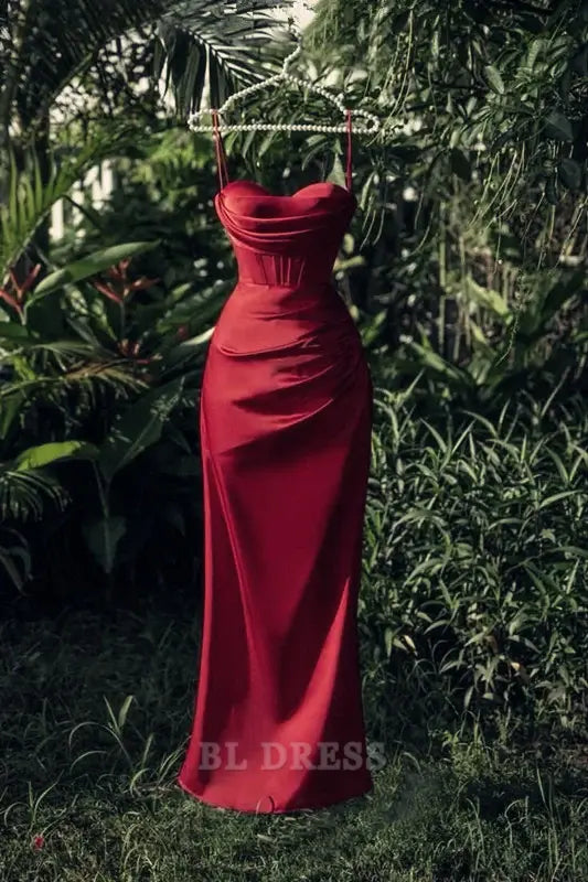 Woman wearing a burgundy strapless satin sheath dress with a high slit.