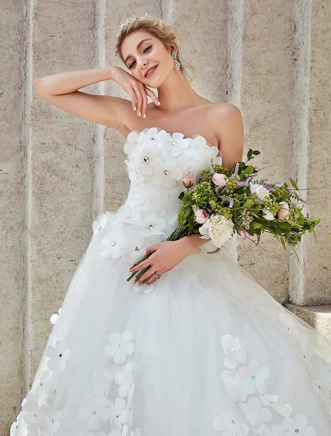 Full length view of a strapless lace wedding dress with a flowing chapel train.