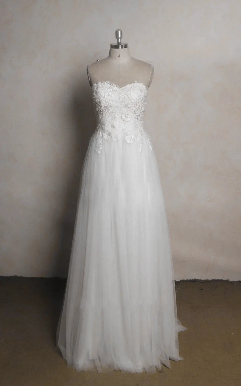 Elegant A-line wedding dress with strapless sweetheart neckline, lace appliques, and beading.