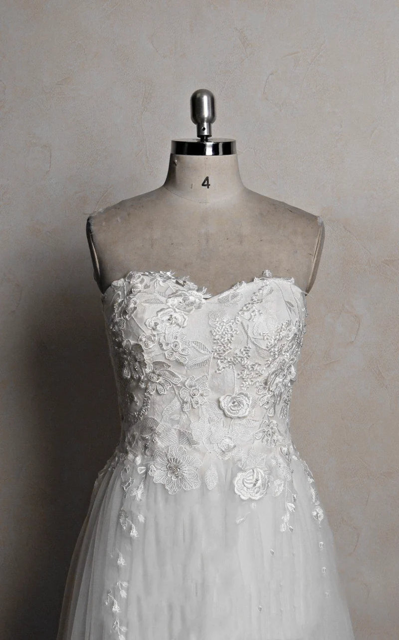 Side profile of a bride wearing a romantic tulle and lace wedding gown.