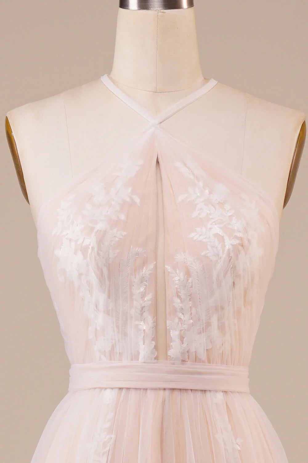 Close-up of the intricate appliques on the tulle fabric of an ivory wedding dress.