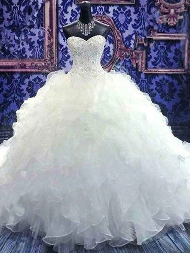 Elegant strapless sweetheart ball gown wedding dress with chapel train and ruffles.