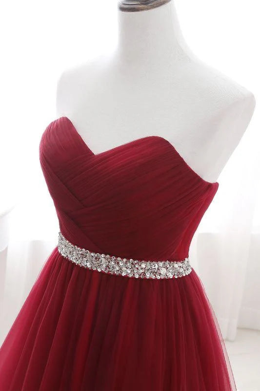 Full view of model wearing strapless tulle prom dress.