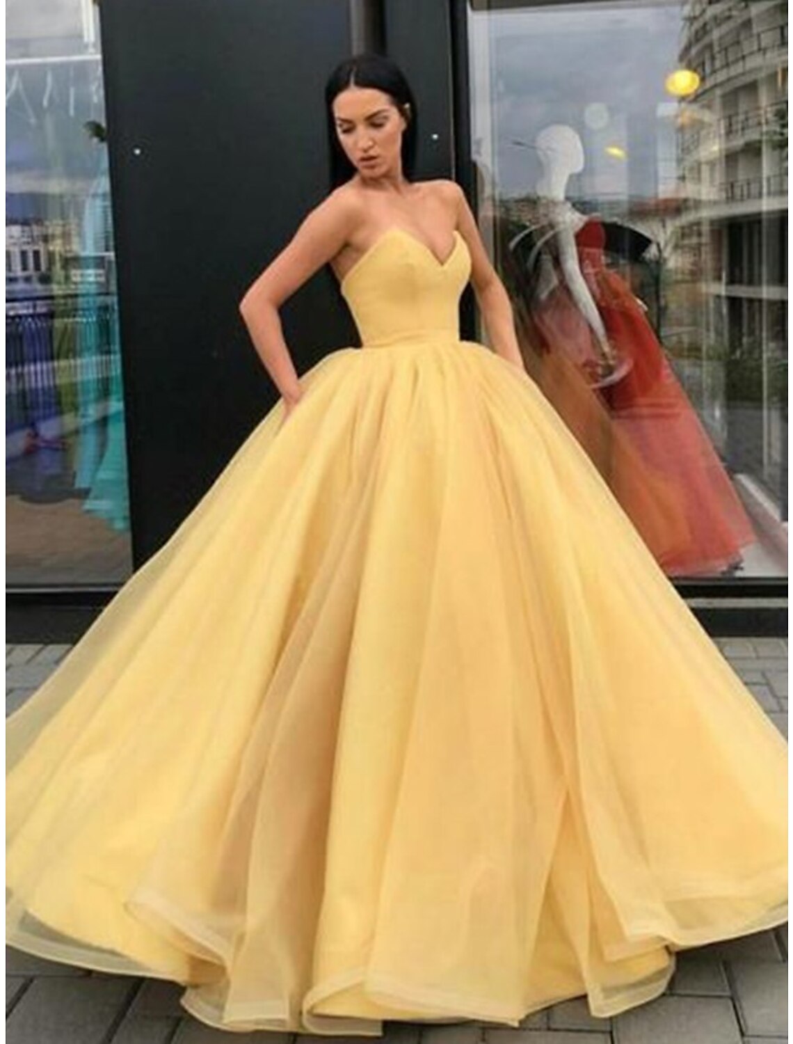 Elegant strapless tulle ball gown with a tiered skirt.