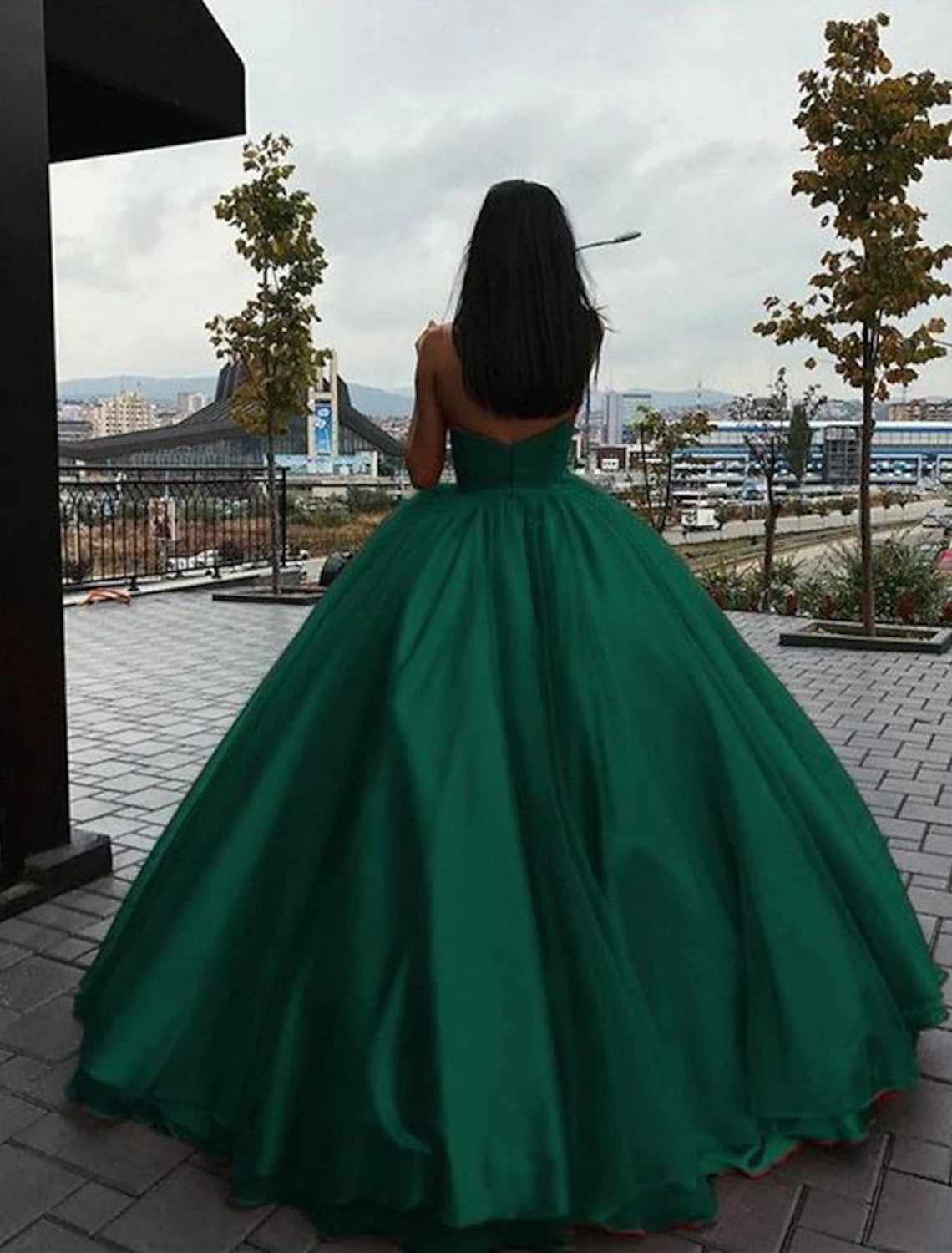 Detailed view of the sleek pleats and tiered tulle skirt of the formal gown.