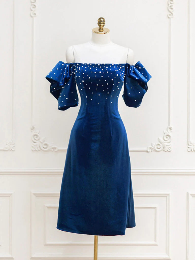 Woman wearing an elegant strapless velvet beaded short prom dress.