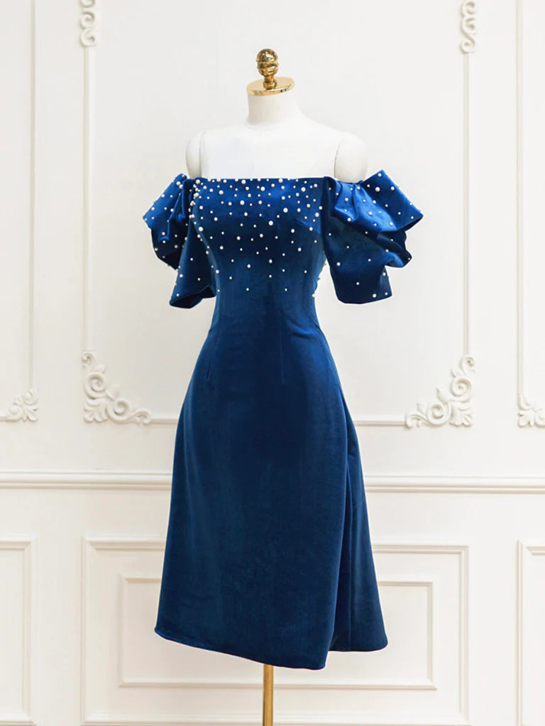 Close-up of the velvet fabric and beaded embellishments on a short prom dress.
