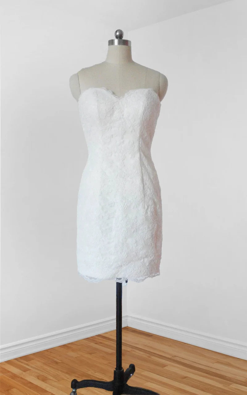 Model wearing an elegant short white lace wedding dress with spaghetti straps, front view.