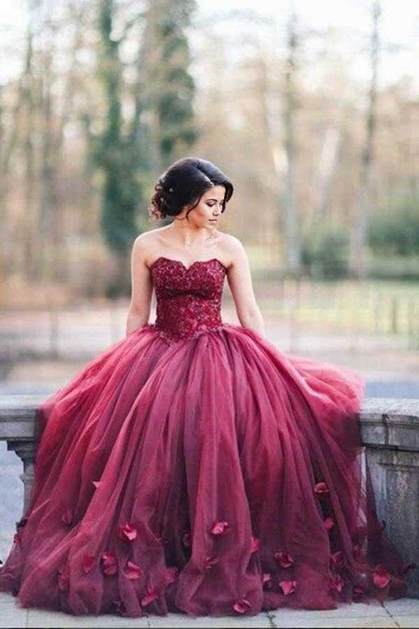 Front view of an elegant burgundy A-line tulle ball gown wedding dress with sweetheart neckline and handmade flowers.