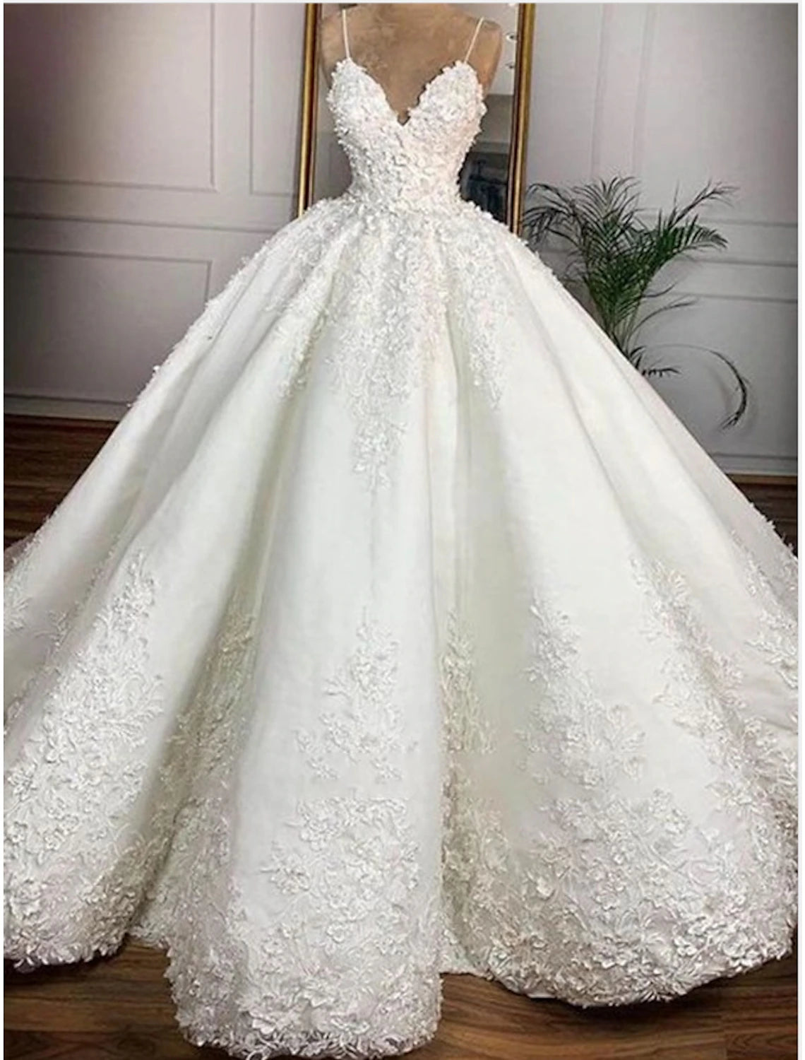 Elegant sweetheart ball gown wedding dress with spaghetti straps, satin fabric, and delicate appliques.