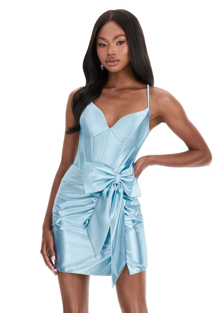 Model wearing a lavender sweetheart corset satin ruched mini homecoming dress with a side bow.