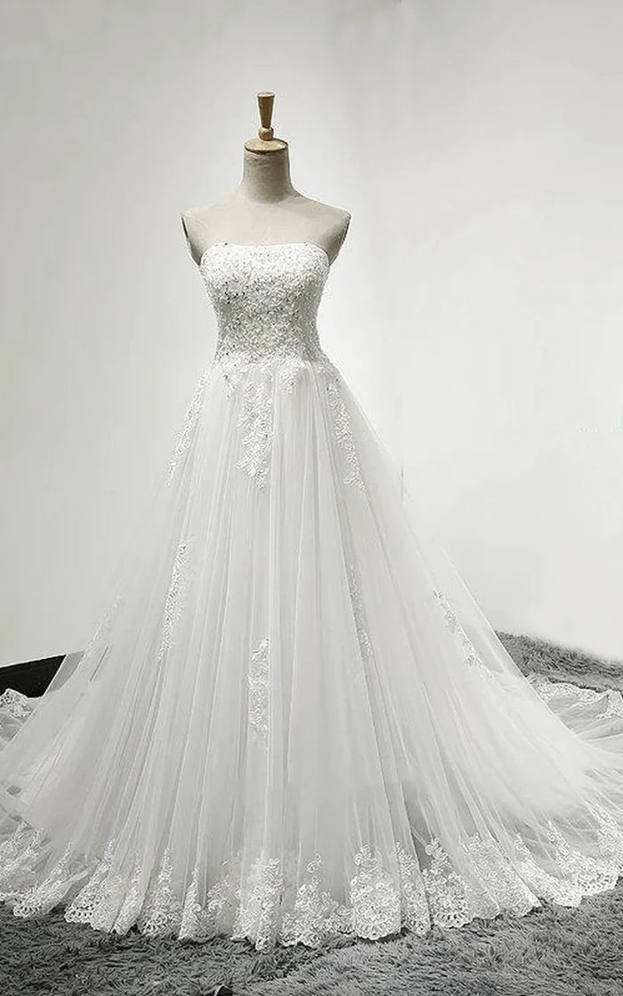 Back view of an elegant white tulle and lace wedding dress with a long court train.