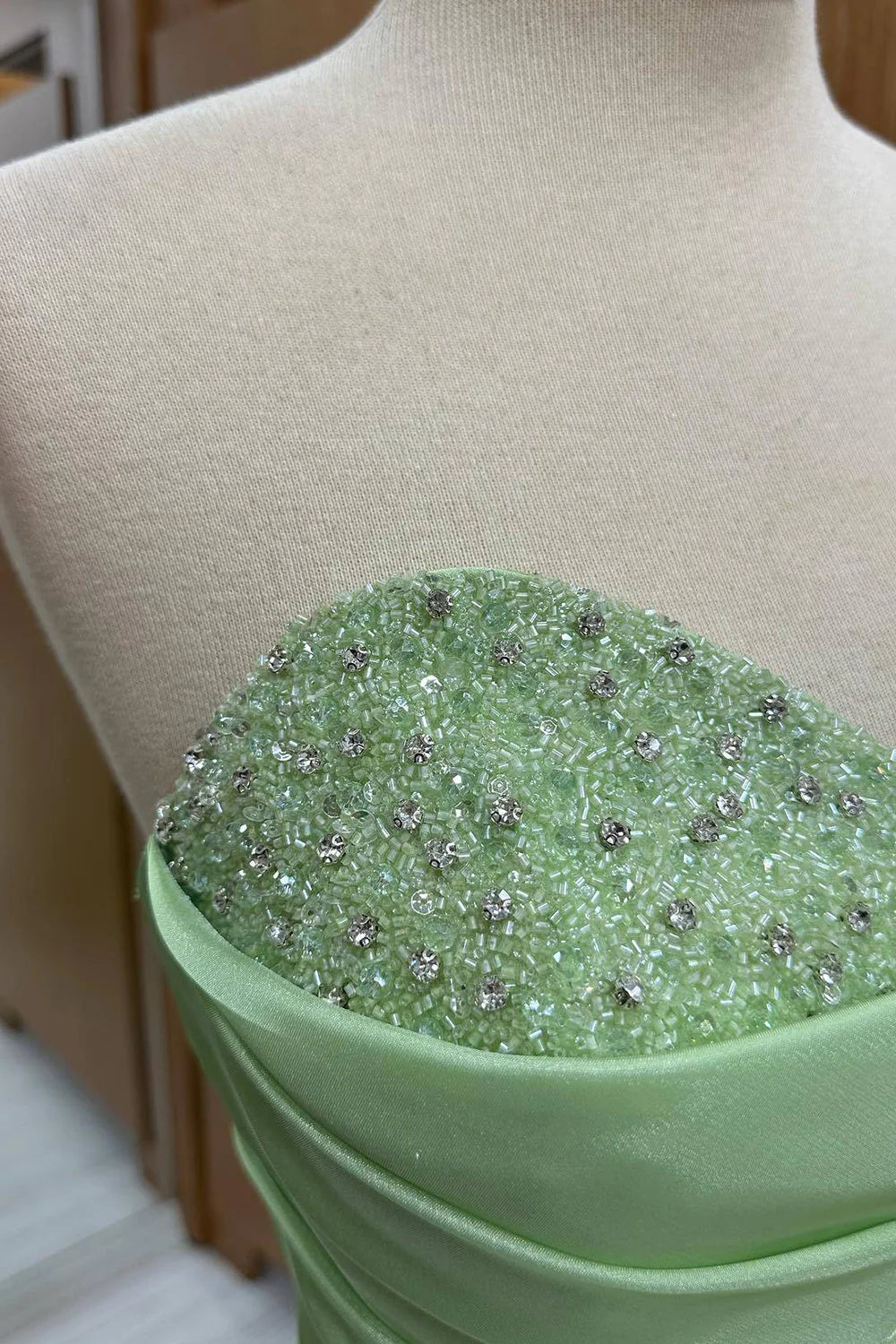 Close-up of the sequined detail on a green prom dress.
