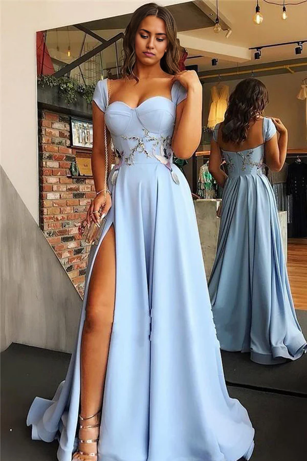Back view of a woman in a flowing satin evening gown with a sweetheart neckline.