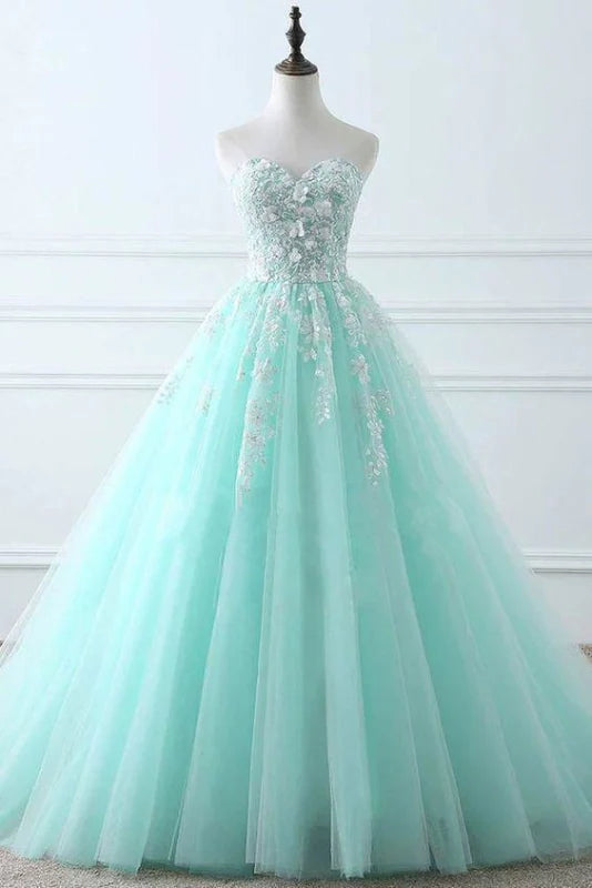 Woman wearing an elegant sweetheart sleeveless tulle lace applique long prom gown.