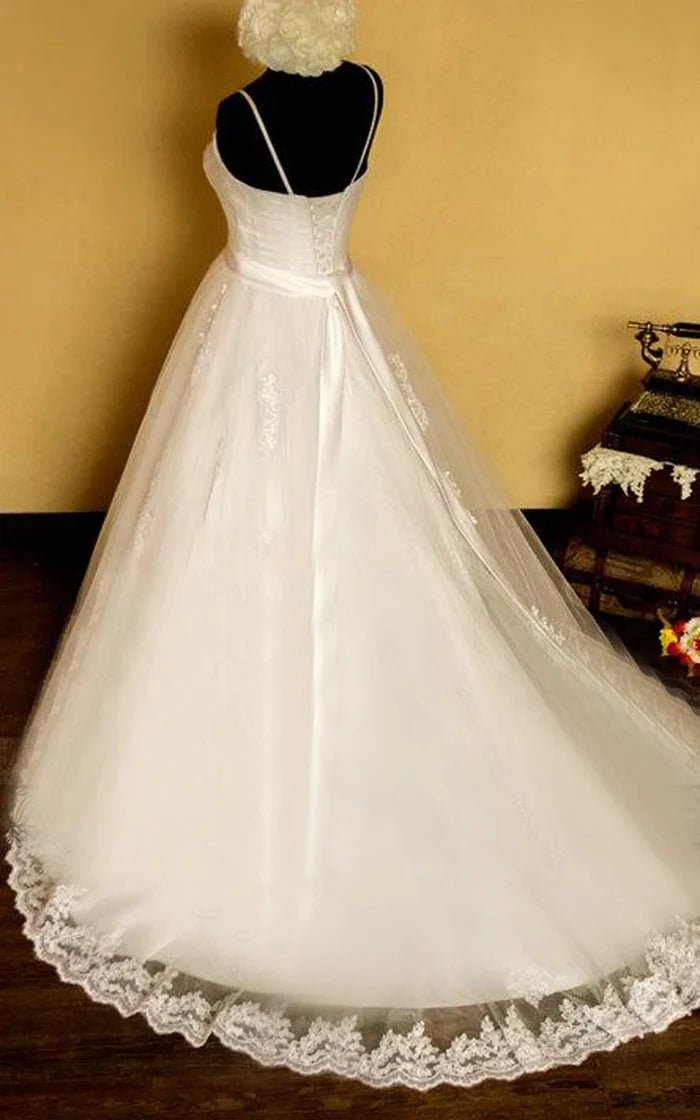Front view of an elegant white A-line wedding dress with spaghetti straps.