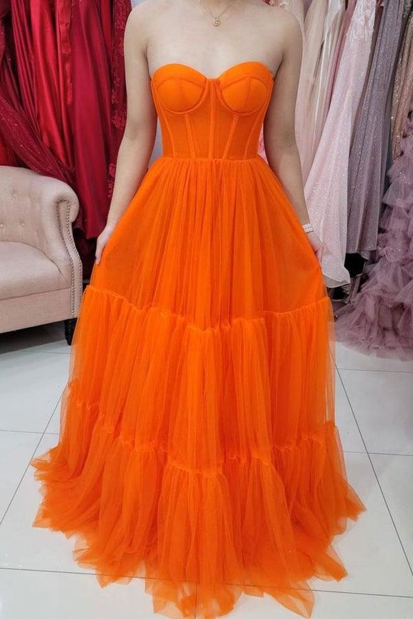 Model wearing a sweetheart strapless tulle corset prom dress.