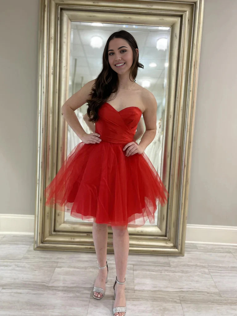 Model wearing a short sweetheart strapless A-line tulle dress.