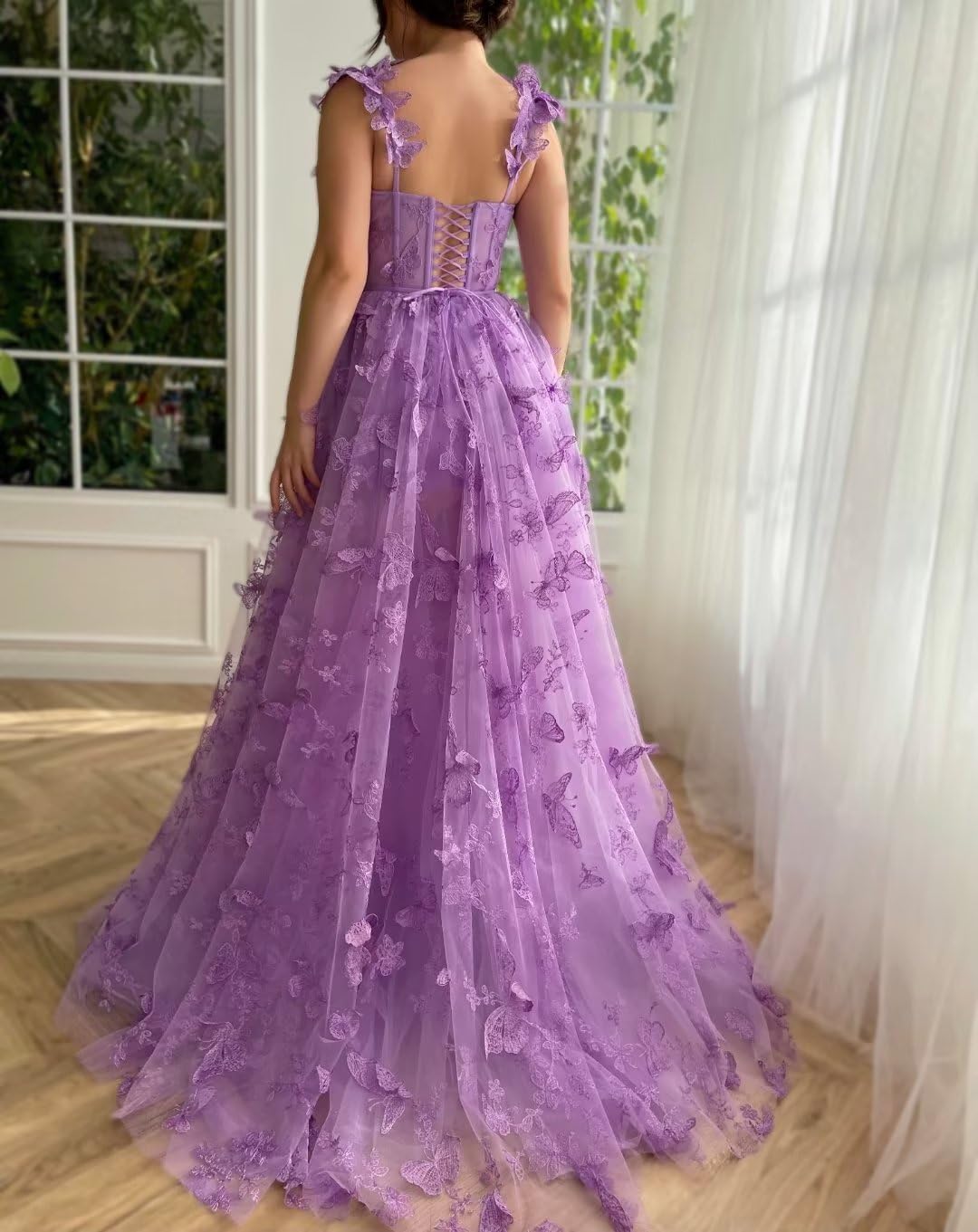 Close-up of the pink tulle dress with delicate 3D butterfly details.
