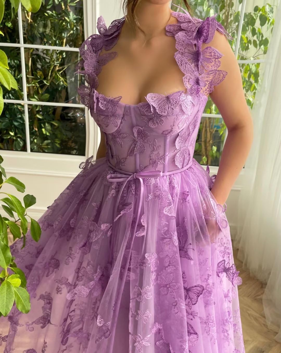 Model posing in the pink tulle dress, highlighting the elegant high slit.