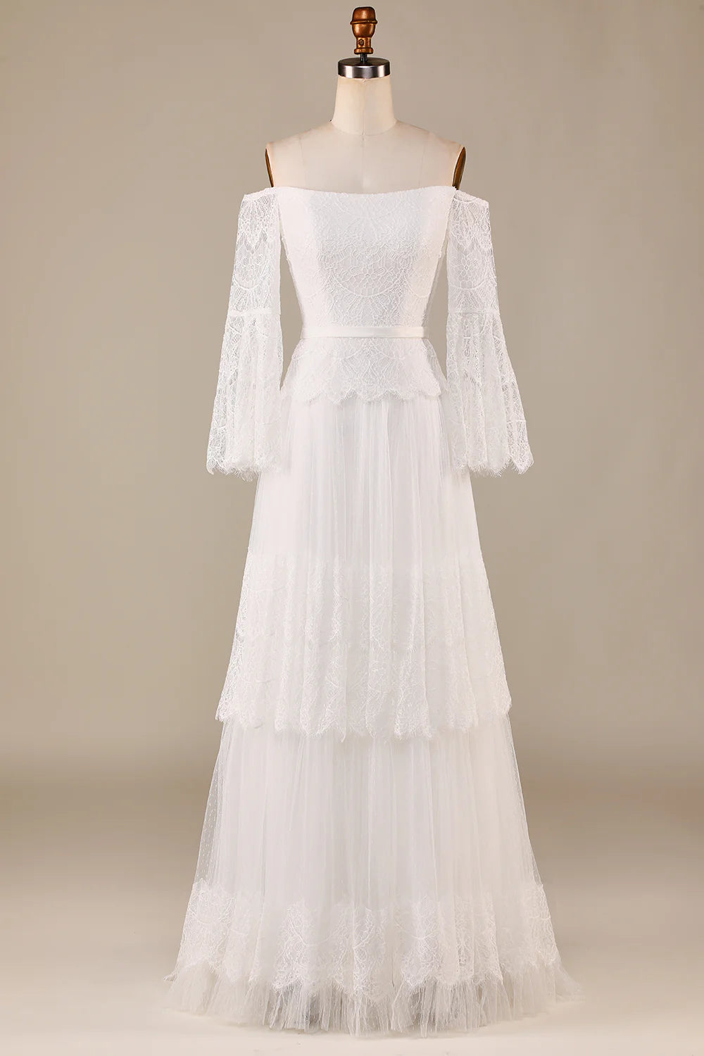 Ivory off-the-shoulder tiered wedding dress with lace details.