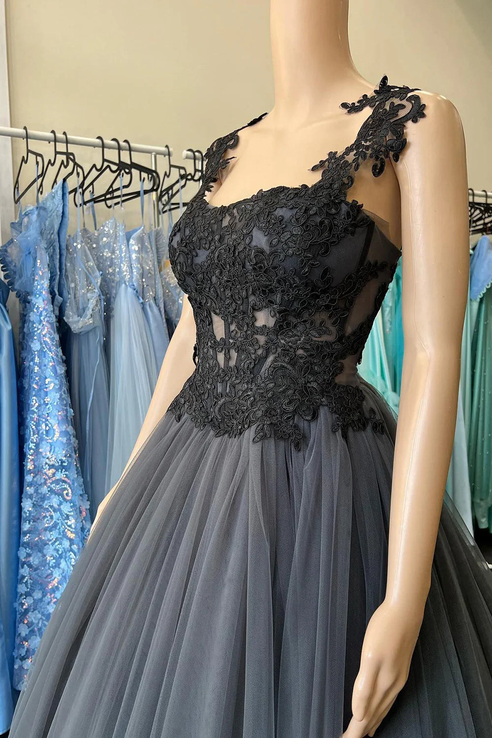 Side view of a black tulle prom dress, showcasing delicate appliques.