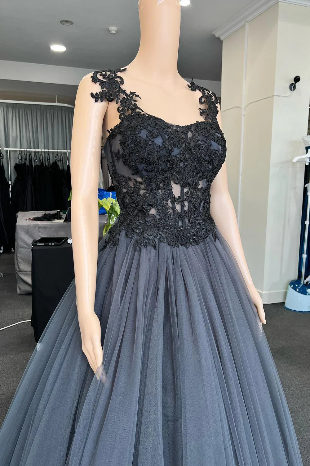 Back view of a black tulle prom dress, highlighting the corset lacing.