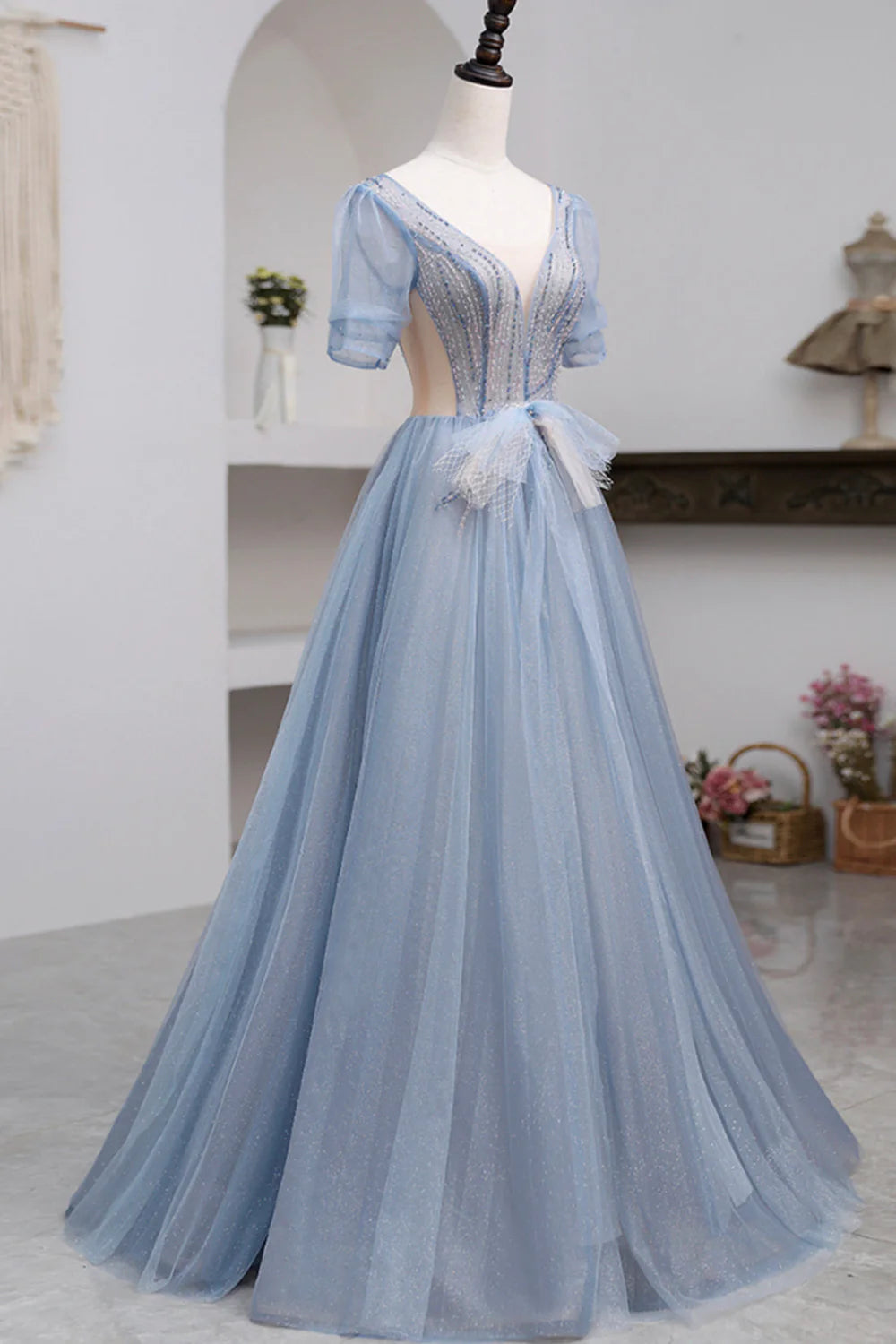 Side profile of the model in the elegant tulle floor length prom dress.