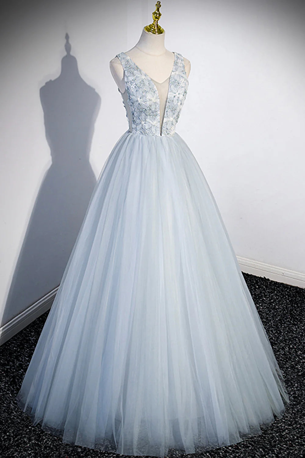 Close-up of the V-neckline and delicate tulle fabric of the long prom dress.