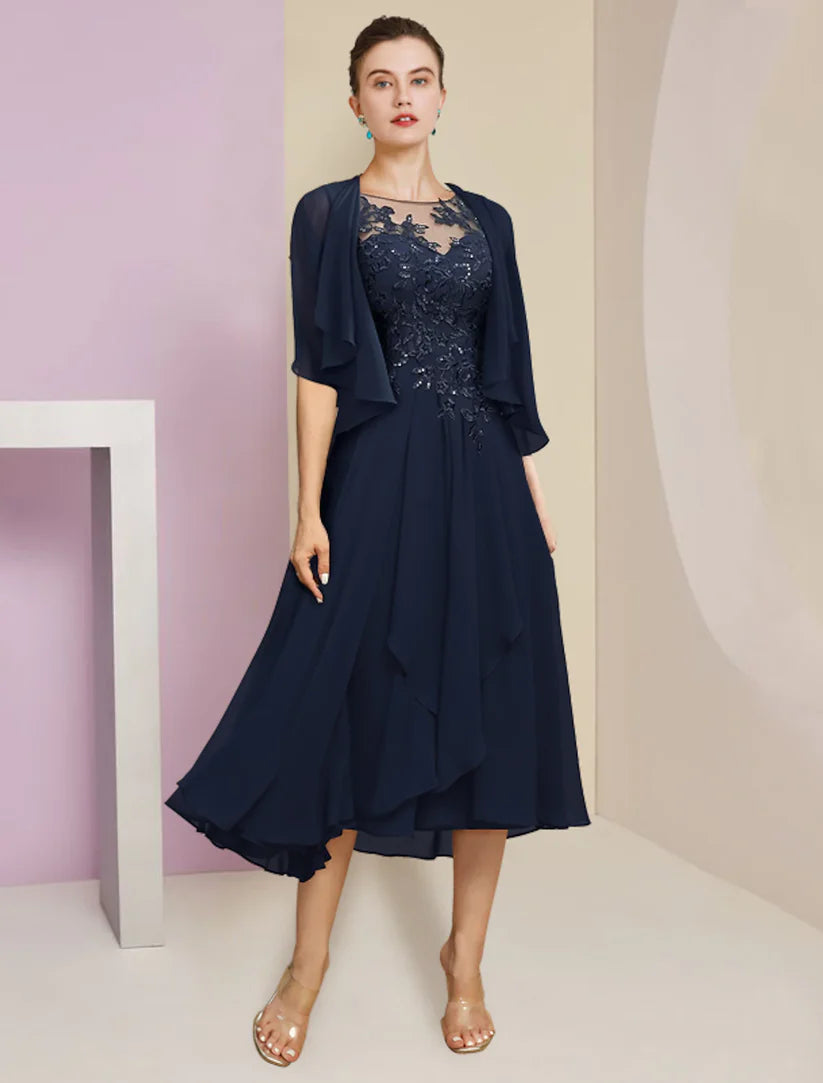 Woman wearing an elegant two-piece A-line tea length dress with lace and sequin appliques, holding a matching chiffon wrap.