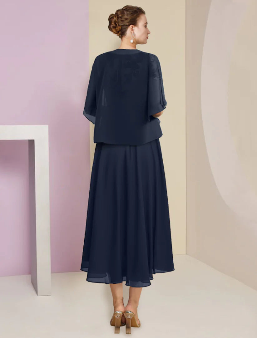 Back view of the two-piece A-line tea length dress, showing the short sleeves and pleated skirt details.