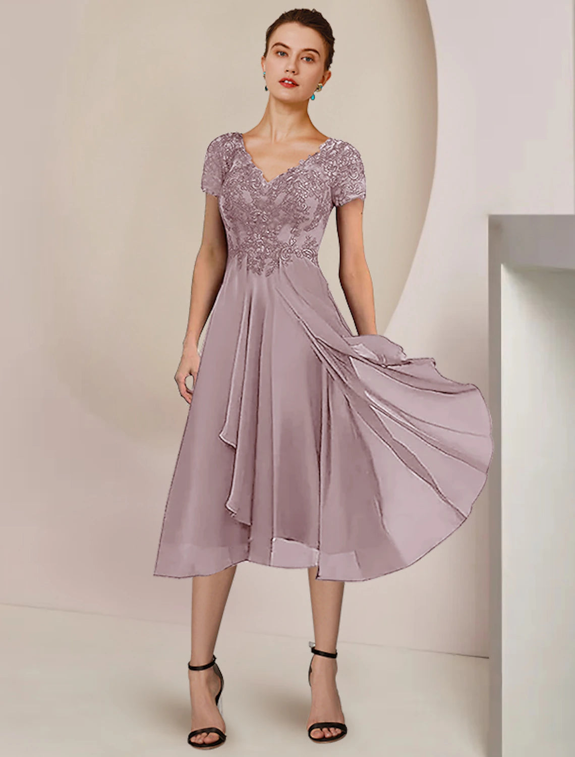 Back view of the tea-length formal wedding guest dress with pleats.