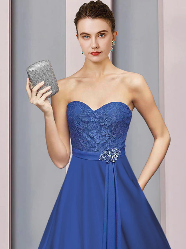 Close-up of the two-piece Mother of the Bride dress showing the half-sleeve wrap and crystal brooch.
