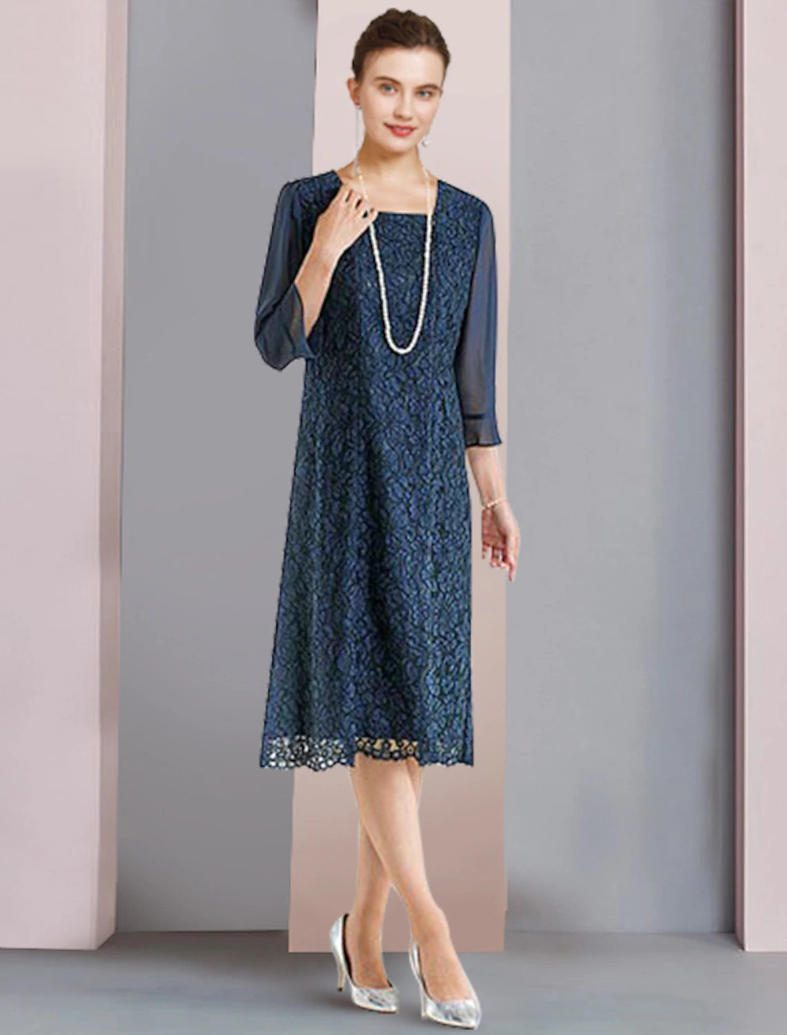 Side view of a woman wearing a tea length chiffon lace mother of the bride dress.
