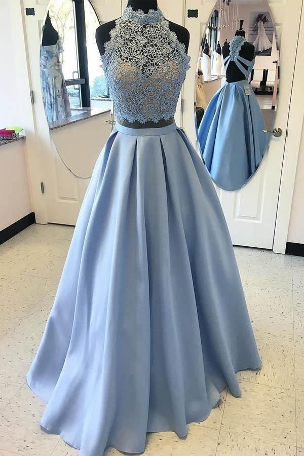 Woman wearing an elegant two-piece lace high neck prom dress with a flowing skirt.