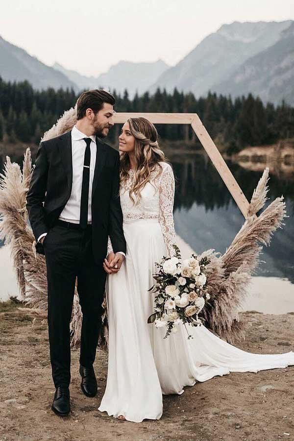 Elegant two-piece ivory wedding dress with lace top and chiffon skirt.