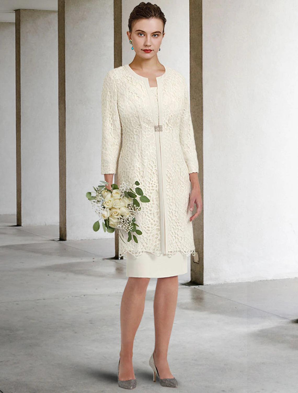 Close-up of the lace detail and crystal brooch on the Mother of the Bride dress.