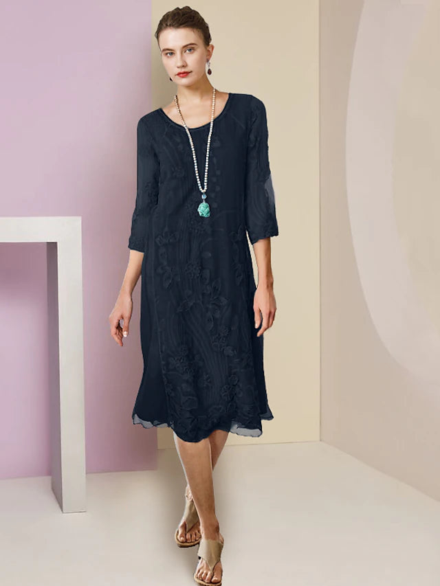 Elegant woman wearing a two-piece sheath mother of the bride dress with a scoop neck and half sleeves.