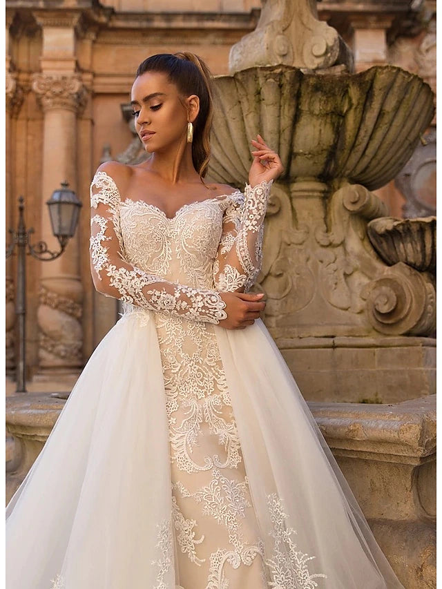 Back view of a formal wedding gown with a flowing court train.