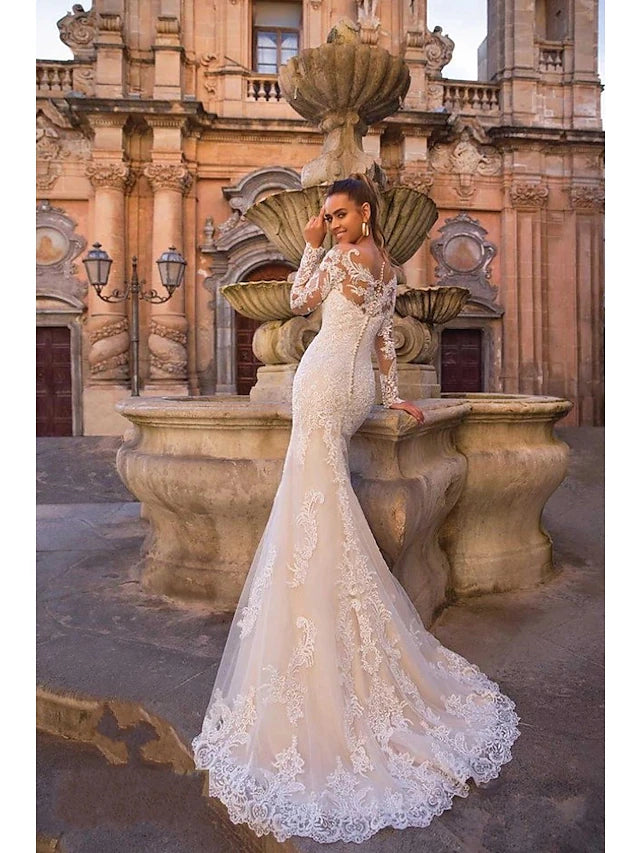 Close-up of intricate lace appliques on a long sleeve wedding dress.
