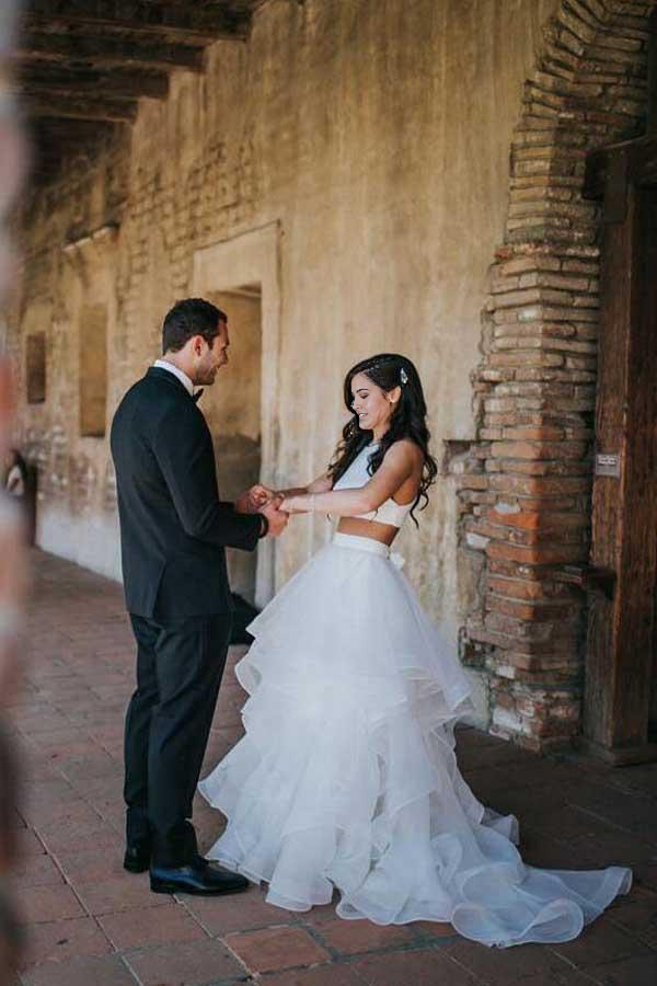 Close-up of the V-neck top and delicate ruffles on the A-line skirt of the white wedding dress.