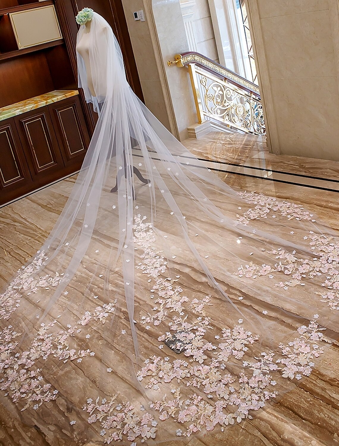 Bride wearing an elegant two-tier cathedral wedding veil with floral lace appliques.