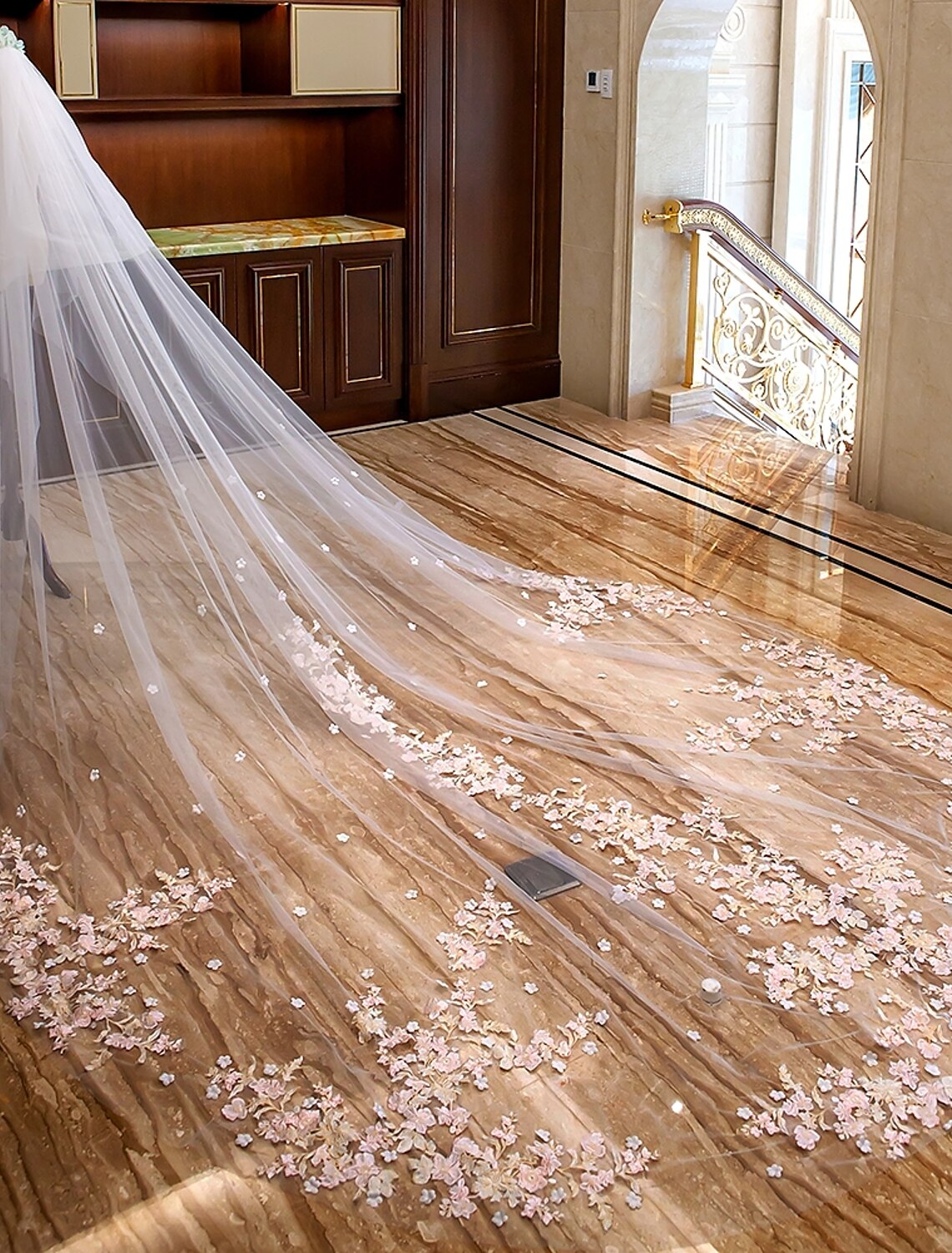 Bride walking, showing the full length of the two-tier cathedral veil.